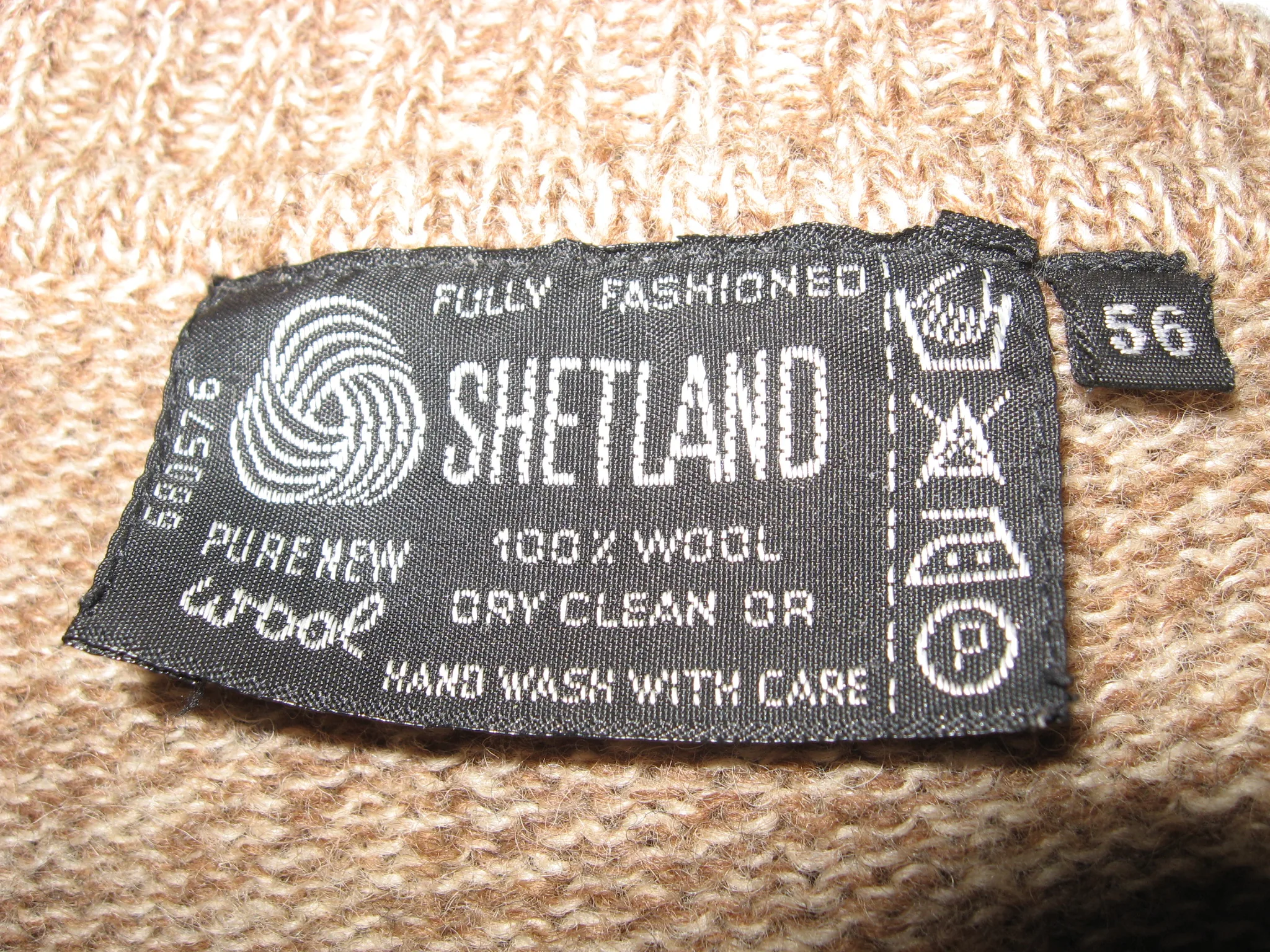 Close-up of a Shetland wool garment label with hand-washing, dry-cleaning and other care symbols.